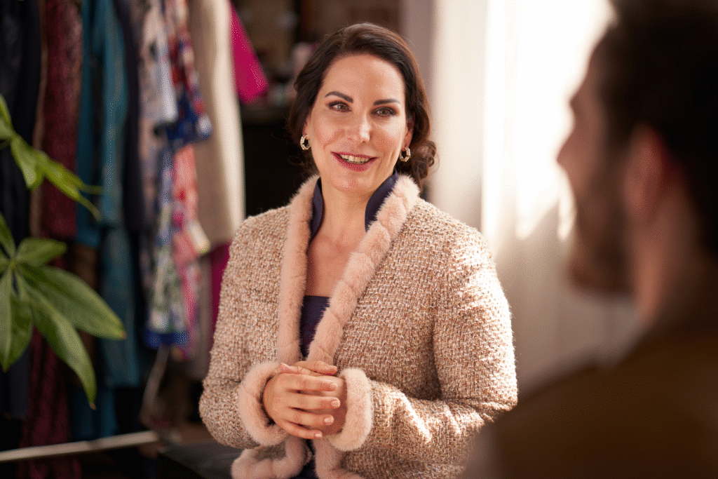 Ein Foto von Prof. Dr. Katrin Winkler, sie schaut eine Person an, die am rechten Bildrand unscharf angedeutet wird.