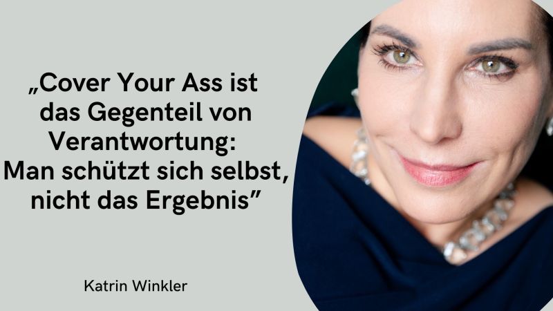 Auf der linken Seite befindet sich ein hellgrauer Hintergrund mit dem zentralen Zitat in schwarzer Schrift: „Cover Your Ass ist das Gegenteil von Verantwortung: Man schützt sich selbst, nicht das Ergebnis“. Ganz unten links steht wieder dezent der Name Katrin Winkler. Die rechte Bildhälfte zeigt ein Porträt der Frau in einer engen Nahaufnahme, die in eine große, geschwungene Form eingefasst ist. Man sieht vor allem ihr Gesicht; sie blickt mit wachen, hellen Augen und einem leichten Schmunzeln direkt den Betrachter an. Sie trägt ein dunkles, navyblaues Oberteil und eine auffällige Gliederkette in Silberoptik. Die gesamte Komposition wirkt sehr klar, direkt und persönlich.